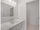 Bathroom featuring a quartz vanity, modern faucet, and large mirror with bright lights over the vanity at 5080 Riverlake Dr, Peachtree Corners, GA 30097