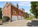 A brick home with three-car garage and landscaped surroundings offers curb appeal and practical parking solutions at 5080 Riverlake Dr, Peachtree Corners, GA 30097
