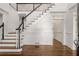 Elegant foyer featuring hardwood floors, a staircase with white spindles, and stylish trim work at 5080 Riverlake Dr, Peachtree Corners, GA 30097