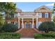 Stately brick home featuring a grand entrance with white columns, an arched front door, and manicured landscaping at 5080 Riverlake Dr, Peachtree Corners, GA 30097