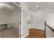 View of a hallway with hardwood floors, opening to an office with custom cabinets through glass french doors at 5080 Riverlake Dr, Peachtree Corners, GA 30097