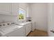 Efficient laundry room with modern washer, dryer, and ample cabinet space at 5080 Riverlake Dr, Peachtree Corners, GA 30097