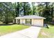 Exterior view of this charming home with a long driveway and well manicured front yard at 8169 Kendrick Rd, Jonesboro, GA 30238