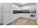 The kitchen features white appliances and cabinets, and a neutral colored backsplash at 8169 Kendrick Rd, Jonesboro, GA 30238