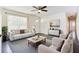 Bright living room features neutral walls, dark floors, ceiling fan, and updated lighting at 8169 Kendrick Rd, Jonesboro, GA 30238