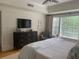 Relaxing bedroom features a window and dresser with a modern TV on top at 3636 Habersham Rd # 2307, Atlanta, GA 30305