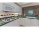 Well-lit kitchen featuring white cabinetry, green countertops and gas stove at 3636 Habersham Rd # 2307, Atlanta, GA 30305