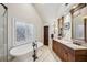 Bright bathroom featuring double vanity, freestanding tub, and natural light from window at 1696 N Pelham Ne Rd, Atlanta, GA 30324