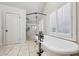 Bright bathroom featuring a standalone tub, glass shower and white shuttered windows at 1696 N Pelham Ne Rd, Atlanta, GA 30324