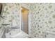 Charming bathroom with floral wallpaper, marble vanity, and glass-enclosed shower at 1696 N Pelham Ne Rd, Atlanta, GA 30324