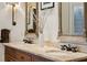 Bathroom featuring double sinks with a marble countertop, wood cabinets, and decorative mirrors at 1696 N Pelham Ne Rd, Atlanta, GA 30324