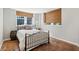 Bedroom featuring a black metal bed frame, natural window shades and brown flooring at 1696 N Pelham Ne Rd, Atlanta, GA 30324