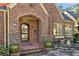 Charming front entrance with brick steps, arched doorway, and lush landscaping at 1696 N Pelham Ne Rd, Atlanta, GA 30324