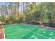 Backyard featuring a well-maintained tennis court surrounded by mature trees and greenery at 1696 N Pelham Ne Rd, Atlanta, GA 30324