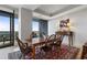 Bright dining room featuring a rustic wooden table, six chairs, and sliding glass doors to a balcony with city views at 3344 Peachtree Ne Rd # 3305, Atlanta, GA 30326