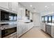 Well-equipped white kitchen with stainless steel appliances, a marble backsplash, and a gas cooktop at 3344 Peachtree Ne Rd # 3305, Atlanta, GA 30326