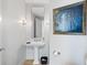 Elegant powder room featuring a pedestal sink, decorative mirror, and stylish wall sconces at 3344 Peachtree Ne Rd # 3305, Atlanta, GA 30326