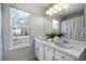 Bright bathroom features a double vanity, white cabinetry, and a large window offering natural light at 4403 Thorngate Ln, Acworth, GA 30101