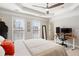 Bedroom featuring a tray ceiling, two windows, a desk, and an adjacent doorway at 4883 Seldon Se Way, Smyrna, GA 30080