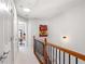 Upstairs hallway with neutral carpet, wood and metal railing and skylight at 4883 Seldon Se Way, Smyrna, GA 30080