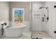 Bright bathroom with a freestanding tub and glass shower with black hardware and subway tile at 939 Whistler Ln, Canton, GA 30114