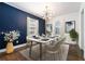 Dining room with a navy accent wall, modern chandelier and seating for six at 1547 Melrose Sw Dr, Atlanta, GA 30310