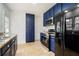 Updated kitchen with granite countertops, blue cabinets, stainless steel appliances, and tile floors at 1547 Melrose Sw Dr, Atlanta, GA 30310