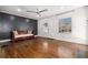 Living room featuring hardwood floors, modern ceiling fan, and a decorative black accent wall at 1547 Melrose Sw Dr, Atlanta, GA 30310