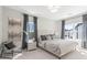 A spacious bedroom boasts two bright windows dressed in elegant gray curtains and tufted headboard at 1991 Hollywood Nw Rd # 14, Atlanta, GA 30318