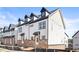 Beautiful new construction townhomes featuring white siding, brick accents, and black trim under a clear blue sky at 1991 Hollywood Nw Rd # 14, Atlanta, GA 30318