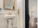 Charming powder room featuring a pedestal sink, wood-framed mirror, and dark hardwood floors at 2005 College Ne Ave, Atlanta, GA 30317