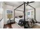 Comfortable main bedroom showcasing a four-poster bed, hardwood floors, and bright windows at 2005 College Ne Ave, Atlanta, GA 30317