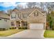 Stunning two-story brick home showcasing a lush green lawn and a double car garage at 5635 Mirror Lake Dr, Cumming, GA 30028