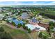 Aerial view of community amenities with pool, tennis courts, clubhouse, parking, and surrounding green space at 1235 Park Pass Way, Suwanee, GA 30024