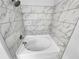 Modern bathroom with bright white soaking tub and marble-style tiled walls and fixtures at 1235 Park Pass Way, Suwanee, GA 30024