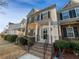 Charming townhome featuring a brick and siding facade, black shutters, and well-manicured landscaping at 1235 Park Pass Way, Suwanee, GA 30024