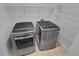 Laundry room features modern washer and dryer with wire shelving at 1235 Park Pass Way, Suwanee, GA 30024