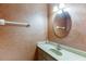 Cozy bathroom featuring textured walls, an oval mirror, and a single sink vanity at 2011 Two Springs Way, Lawrenceville, GA 30043