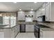 Open kitchen featuring stainless steel appliances, granite counters, tiled backsplash, and bright overhead lighting at 2011 Two Springs Way, Lawrenceville, GA 30043