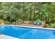 Inviting pool deck area with outdoor dining set, chairs, and ample room for relaxation at 2011 Two Springs Way, Lawrenceville, GA 30043