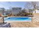 Backyard view featuring a refreshing swimming pool and a spacious wooden deck with a multi-story home backdrop at 2011 Two Springs Way, Lawrenceville, GA 30043