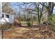 Backyard with a wooden deck and surrounded by natural landscaping and tall trees at 248 N Lake Dr, Jonesboro, GA 30236