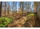 Picturesque backyard with mature trees, lush greenery, and a stone pathway leading to upper deck at 2704 Loring Nw Rd, Kennesaw, GA 30152