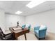 Well-lit basement featuring two cozy armchairs, a desk, and an adjacent unfinished storage area at 2704 Loring Nw Rd, Kennesaw, GA 30152