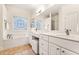 Spacious bathroom featuring double sinks, quartz countertop, soaking tub and stylish tile flooring at 2704 Loring Nw Rd, Kennesaw, GA 30152