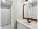 Bright bathroom with white vanity, wood-trimmed mirror, and a shower with decorative curtain at 569 Alexander Farms Sw Vw, Marietta, GA 30064