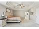 Main bedroom with a large bed, tray ceilings, and a view into the hallway, and a bathroom at 569 Alexander Farms Sw Vw, Marietta, GA 30064