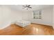 Sunlit bedroom featuring hardwood floors, ceiling fan, and a bed, with a large window at 2146 Greensward Ne Dr, Atlanta, GA 30345