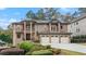 Elegant brick home featuring a three-car garage, manicured lawn, and a charming double-door entrance at 2146 Greensward Ne Dr, Atlanta, GA 30345
