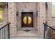 Grand double front door with decorative glass, set in a brick facade with elegant sconces and iron railings at 2146 Greensward Ne Dr, Atlanta, GA 30345